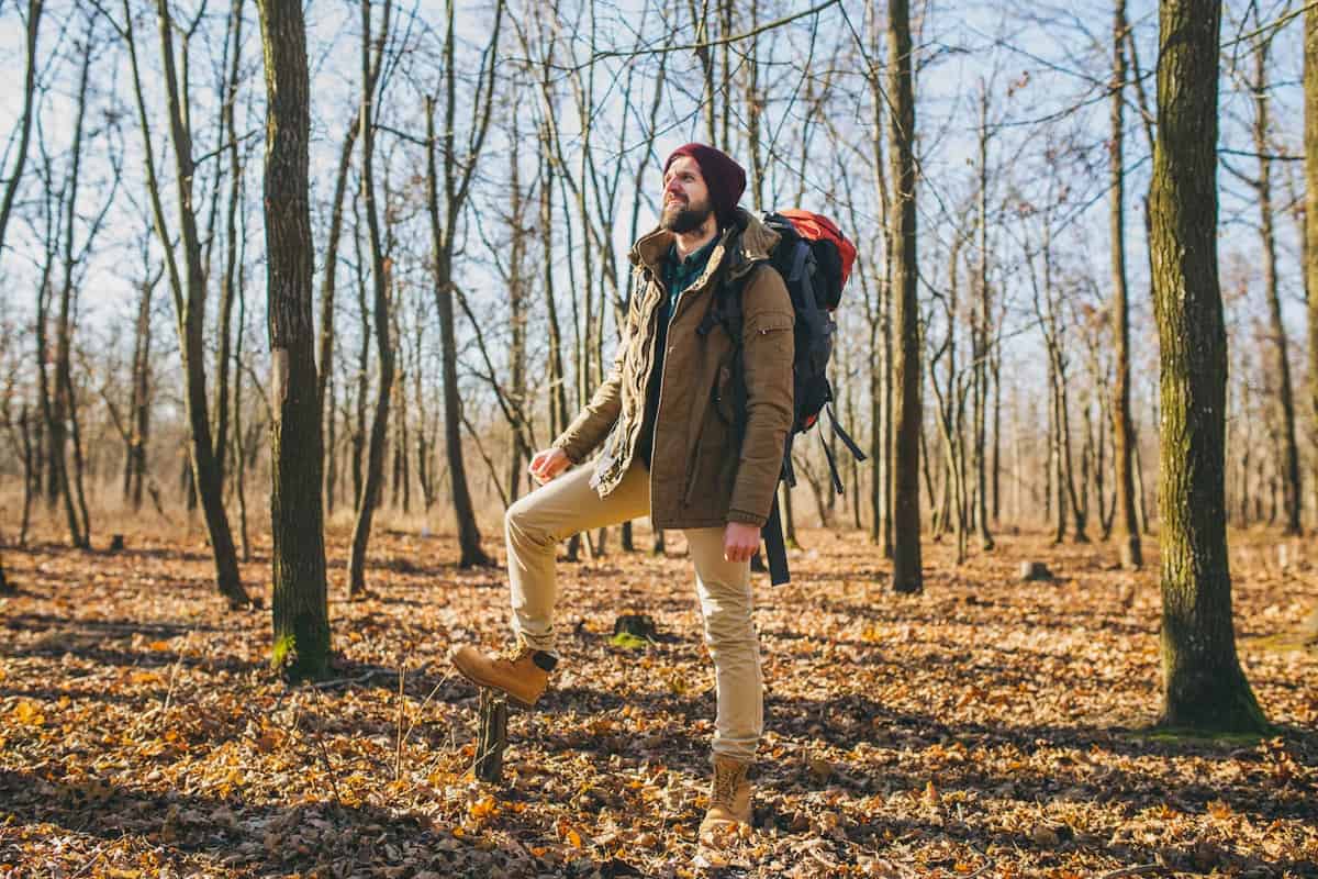 A man with a large backpack traveling in nature.